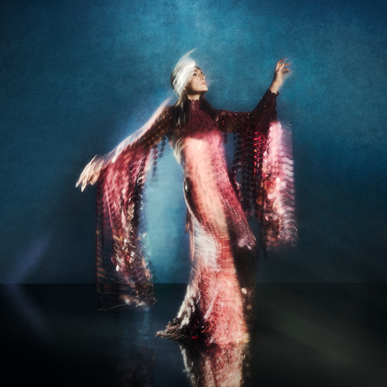 Jessie Ware in flowing red dress with motion blur lighting for Superbloom era visuals