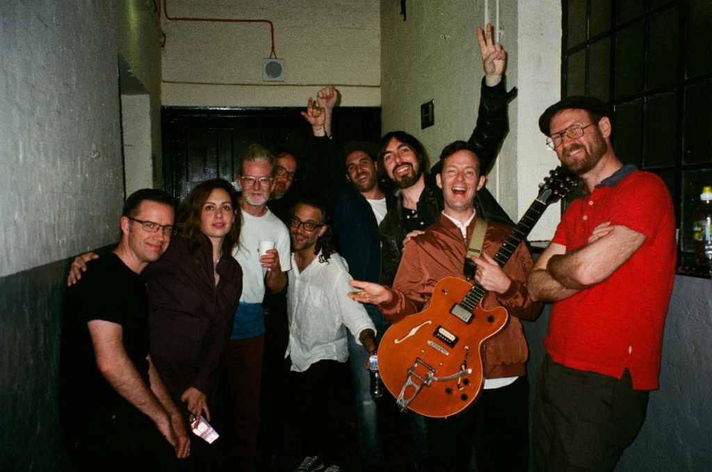Broken Social Scene band members posing together backstage in 2026 group photo