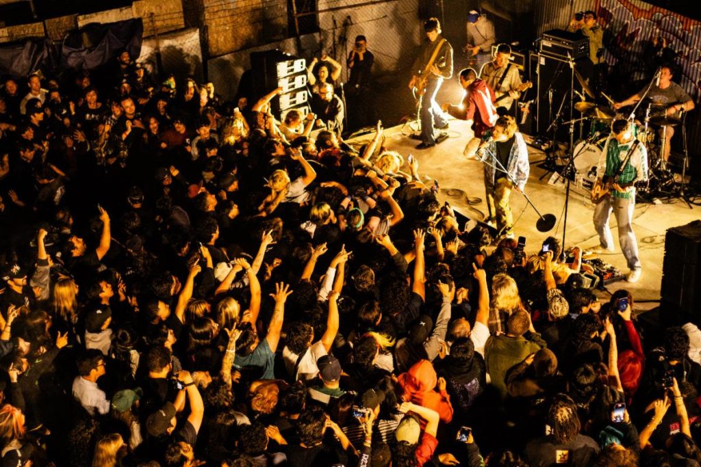 Basement performing live to packed crowd with stage diving and raised hands