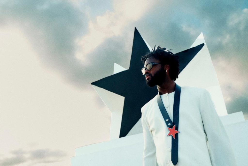 Genesis Owusu Redstar Wu album artwork style press photo with star monument and white suit