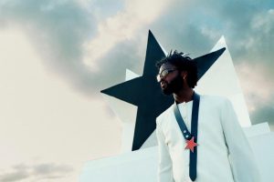 Genesis Owusu Redstar Wu album artwork style press photo with star monument and white suit