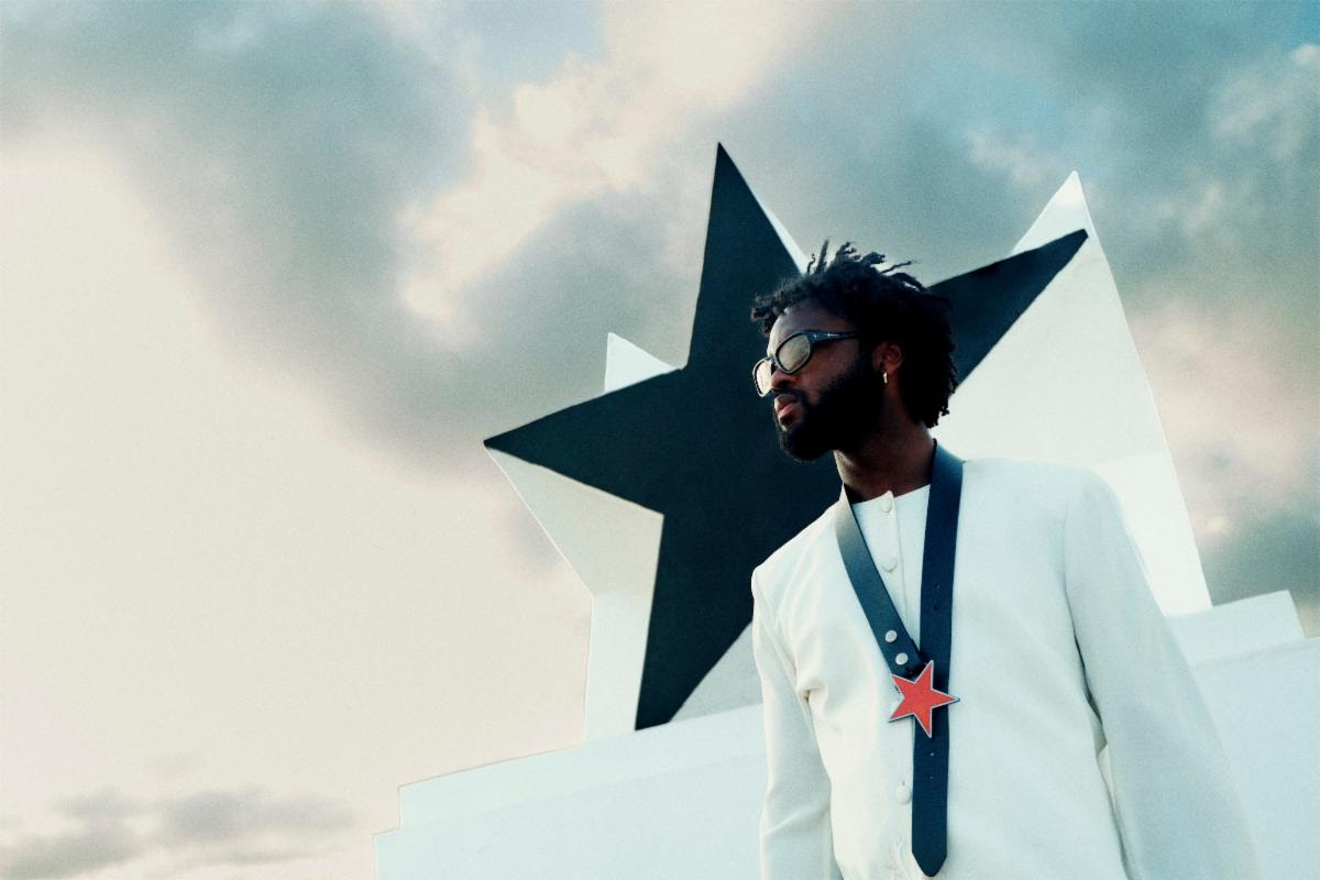 Genesis Owusu Redstar Wu album artwork style press photo with star monument and white suit