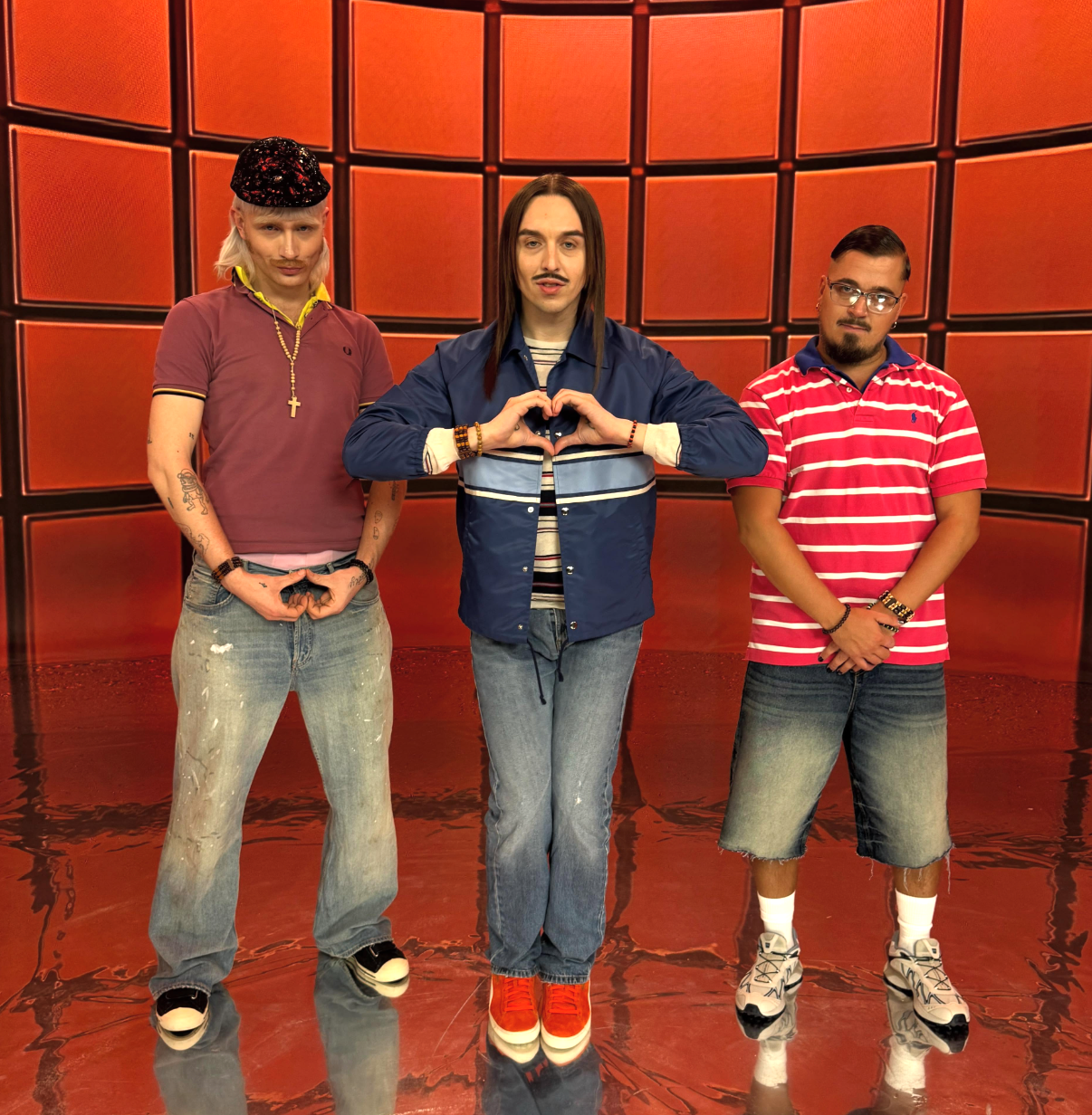 Joost Klein, Käärijä and Tommy Cash pose together in a bright orange studio set promoting their collaborative Boyband EP
