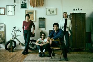 Telescreens band members posed in a vintage styled room with instruments and decor in New York