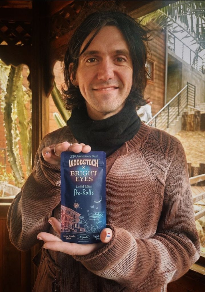 Conor Oberst holding Woodstock x Bright Eyes limited edition pre-rolls pack