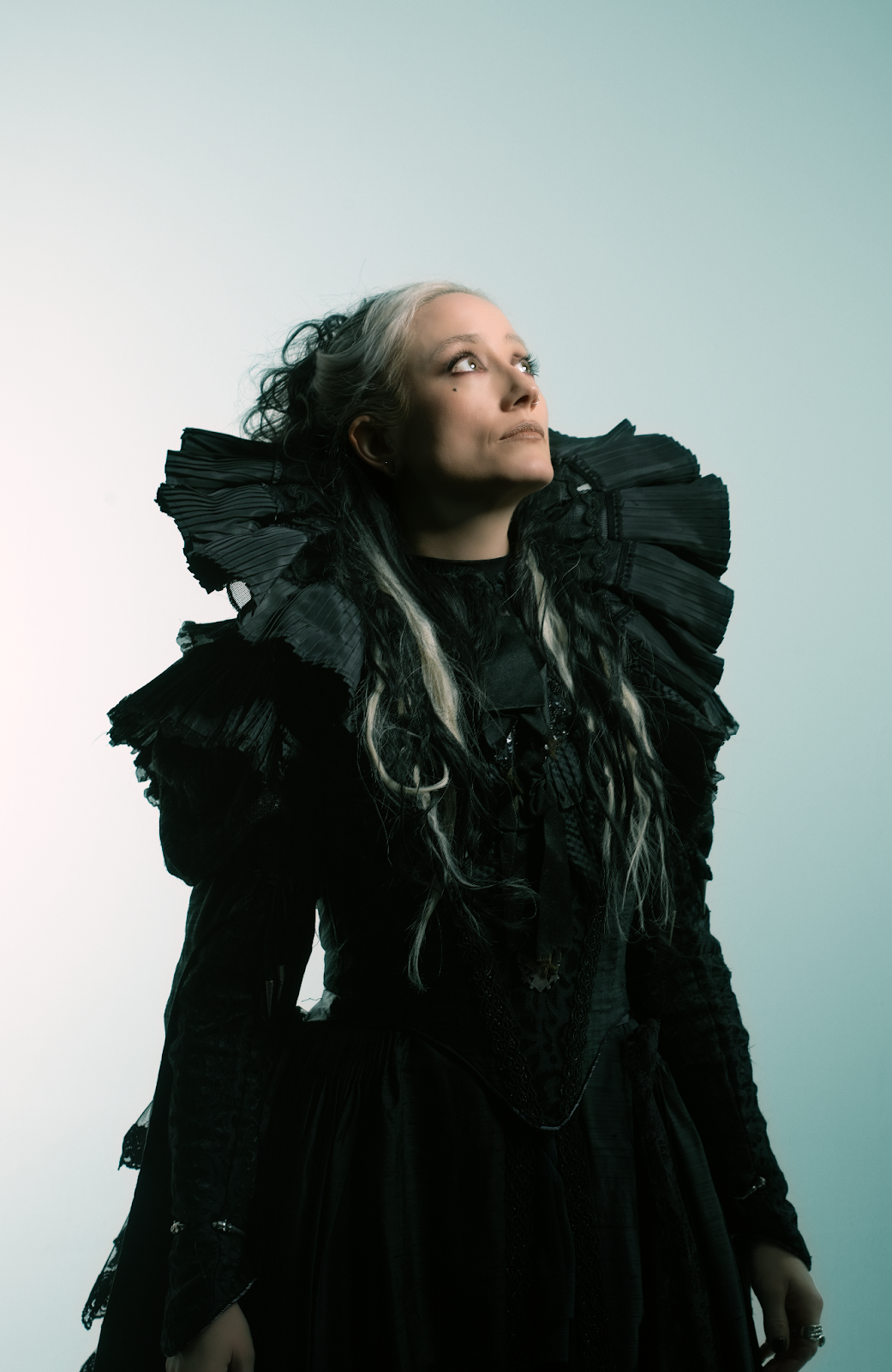 HAYLA in black gothic dress looking upward in dramatic portrait lighting