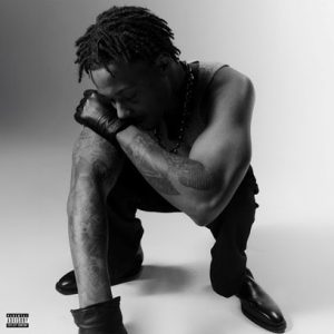 Cover art for Skilla Baby’s single “GYSM” featuring the Detroit rapper crouched in a black-and-white portrait wearing gloves and a chain necklace.