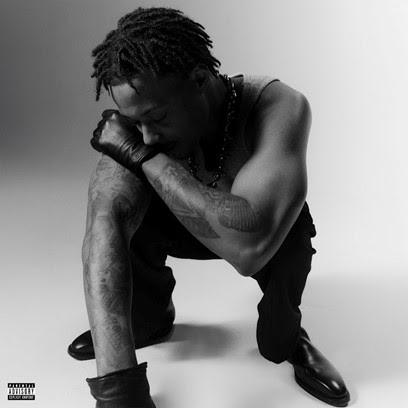 Cover art for Skilla Baby’s single “GYSM” featuring the Detroit rapper crouched in a black-and-white portrait wearing gloves and a chain necklace.