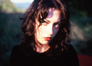 Violet Grohl close-up portrait with dark wavy hair, red lipstick and dramatic natural lighting promoting her debut album Be Sweet To Me