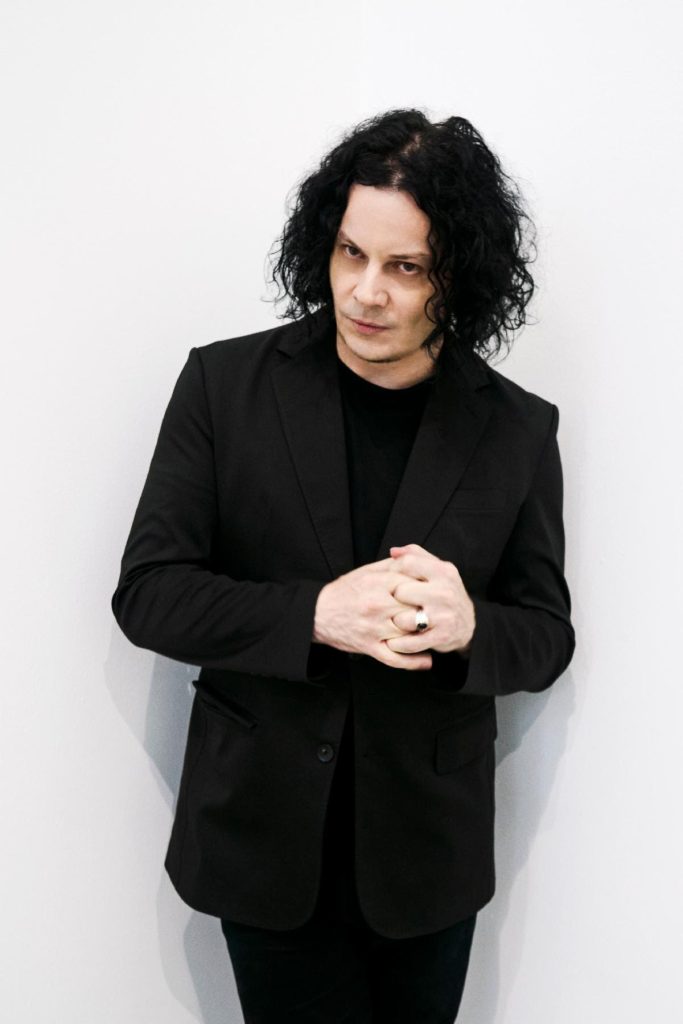 Jack White poses in a black suit in an official portrait promoting his album Frozen Charlotte