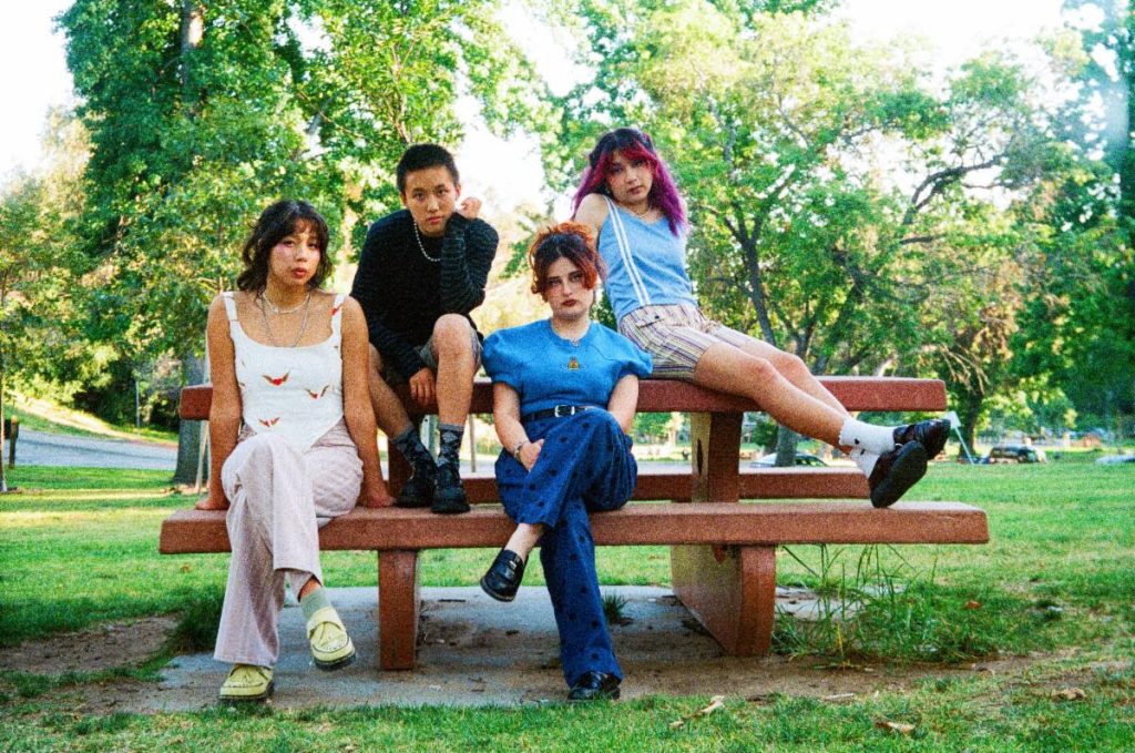 The Linda Lindas pose together in a Los Angeles park following the release of their new single "Burning Out" and signing with Reprise Records