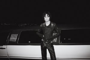 SOMBR poses in front of a limousine promoting his 2026 single "My Body Isn't Ready" and upcoming album and arena tour.