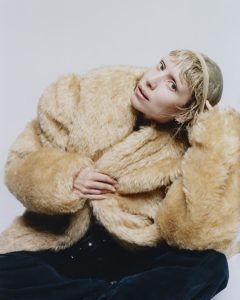 Lykke Li wearing an oversized faux fur coat while posing for promotional photos during The Afterparty era