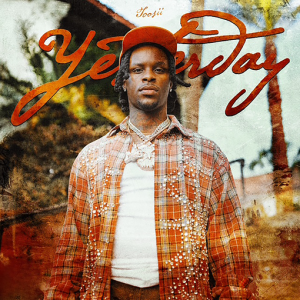 Toosii stands outdoors wearing an orange plaid shirt and cap on the cover art for his 2026 single “Yesterday”
