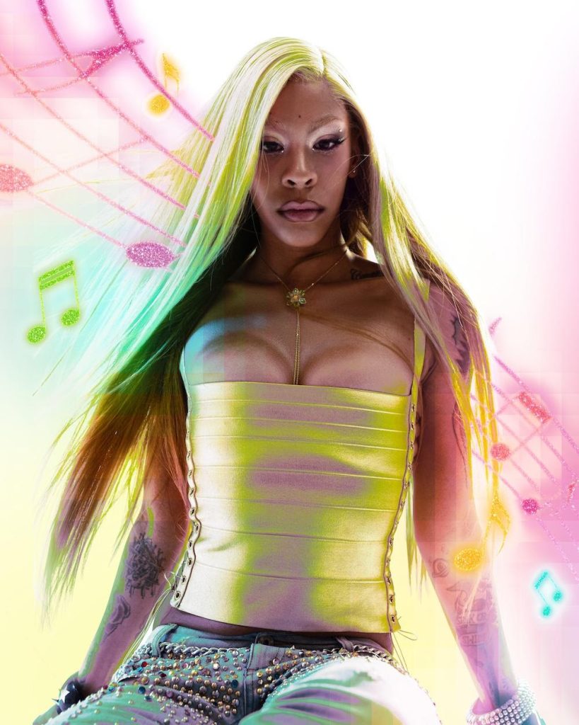 Rico Nasty poses in a neon fashion portrait promoting her 2026 album RX, produced by Kenneth Blume.
