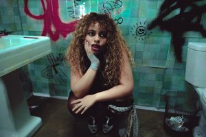 Bella Kay poses in a graffiti-covered bathroom ahead of the release of her debut album My Reckless Abandon.