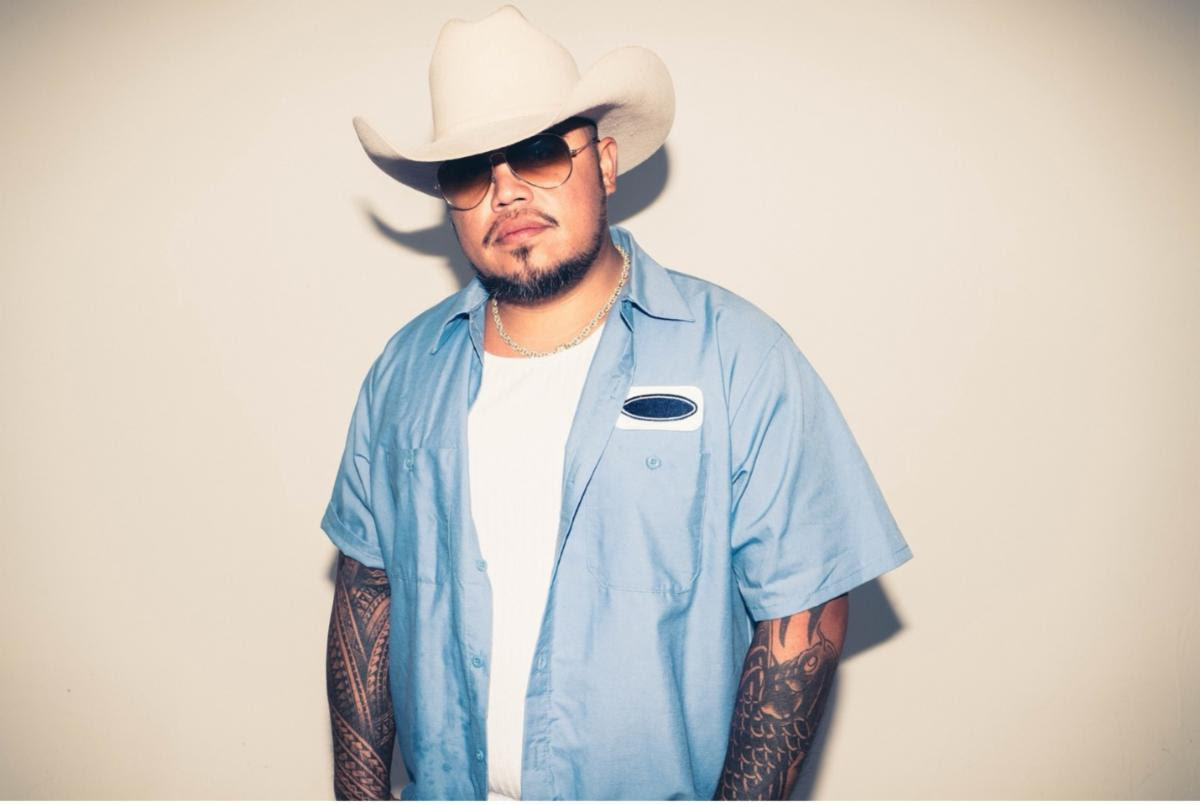 Hawaiian country reggae artist Maoli wearing a white cowboy hat and blue button-up shirt in a 2026 promotional portrait