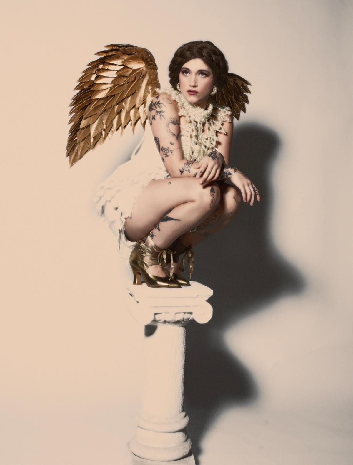 Sierra Ferrell wearing gold wings and posing on a pedestal for a 2026 press portrait.