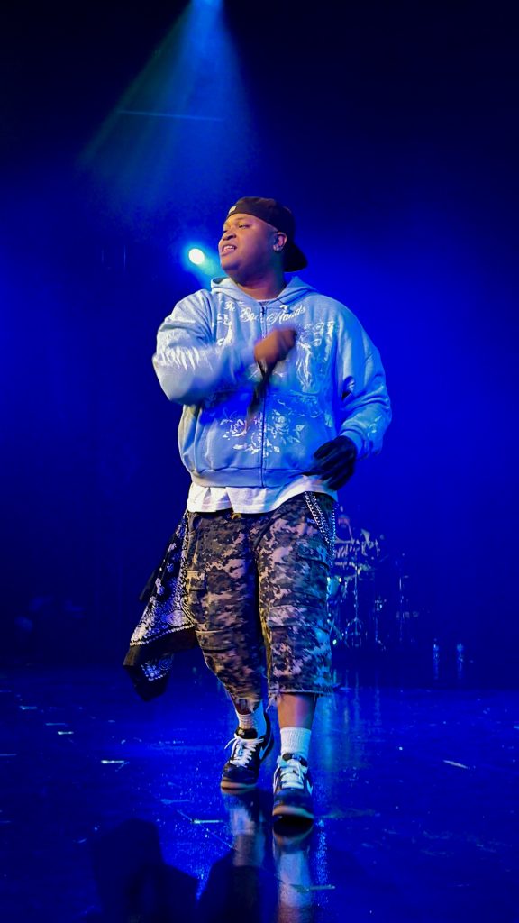 Aaron Cole performs onstage during GLO Fest 2026 in Mountain View, California, engaging fans from the edge of the stage.