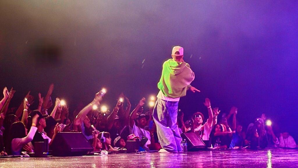 Christian hip-hop artist Jon Keith performs during GLO Fest while fans cheer from the barricade.