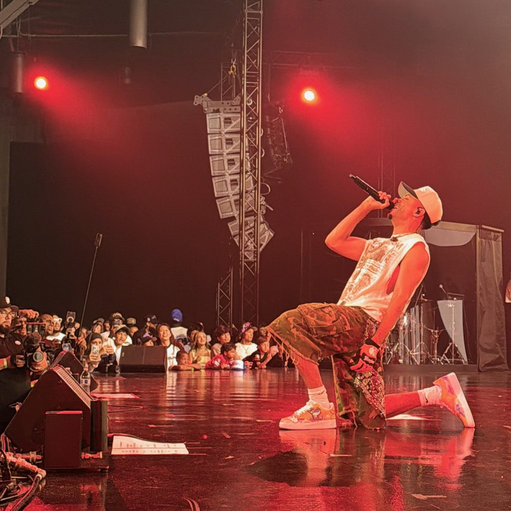 Miles Minnick kneels while performing during GLO Fest 2026 in Mountain View.