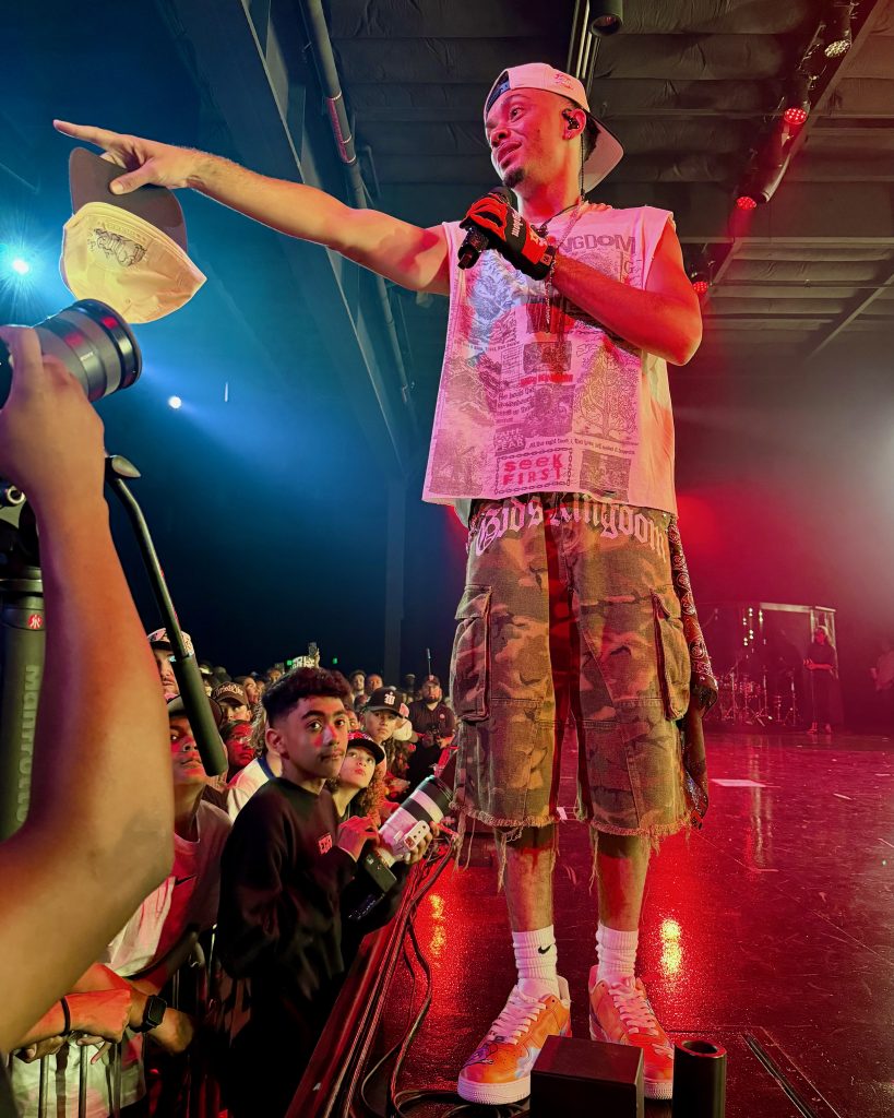 Miles Minnick performs from the edge of the stage while engaging front-row fans during GLO Fest.