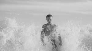 Nettspend standing chest-deep in the ocean in a black-and-white still from “sober”