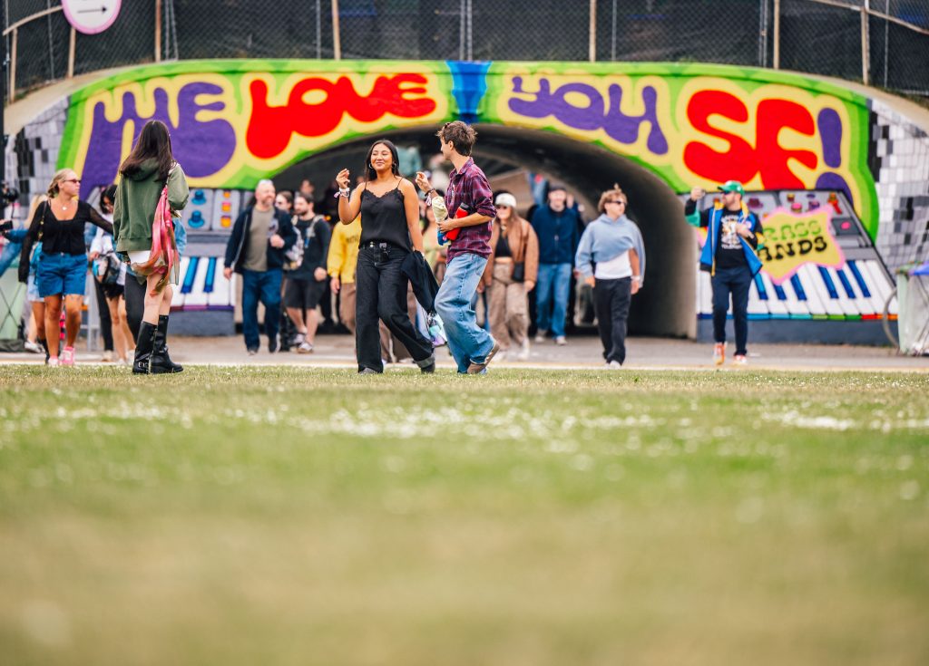 Festivalgoers outside the colorful We Love You SF tunnel at Outside Lands 2026