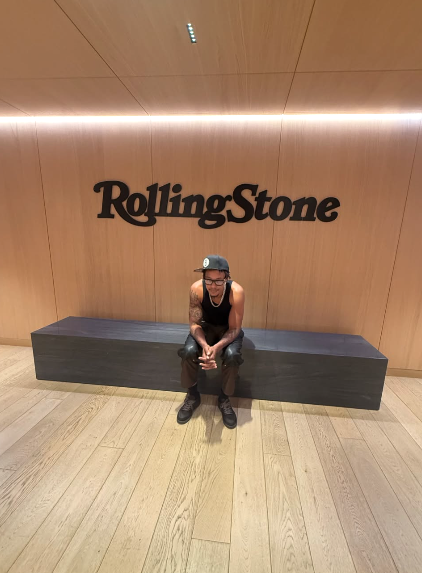 Skilla Baby sitting beneath the Rolling Stone logo during promotion for his debut album The Price of Fame