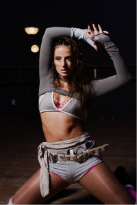 Natalie Jane poses in a gray performance outfit for the release of her 2026 dance-pop single "Dance Til I Die."