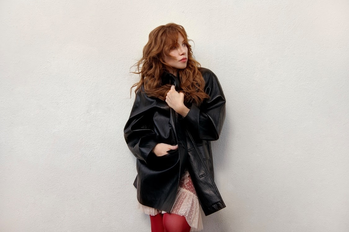 Carly Rae Jepsen poses in a black leather jacket ahead of the release of her 2026 double album Day and Night.