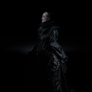 GRAMMY-nominated singer-songwriter HAYLA wearing an elegant Victorian-inspired black gown in a dramatic portrait promoting her 2026 album DARK.