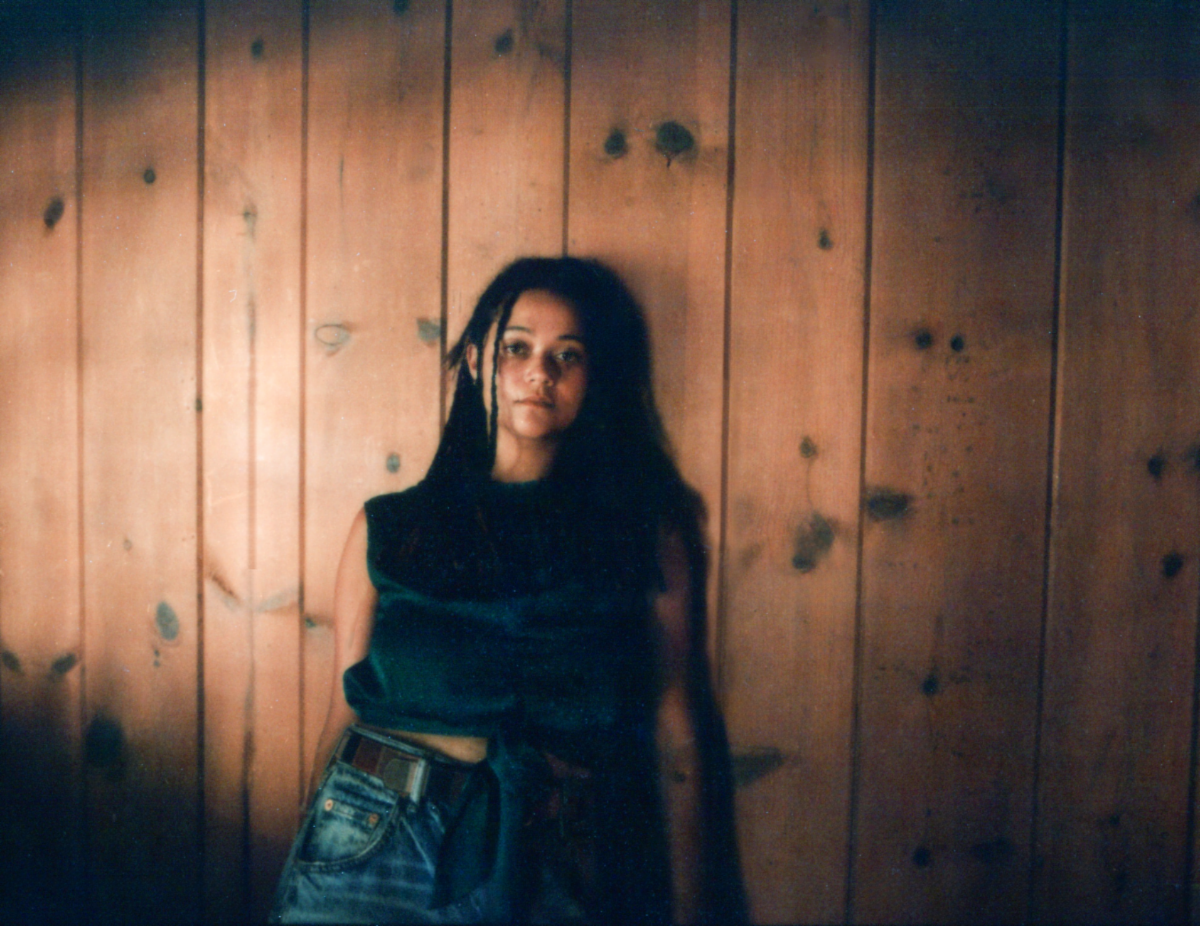 Khatumu poses against a wood-paneled wall in a press photo for her new single “Clothes On.”