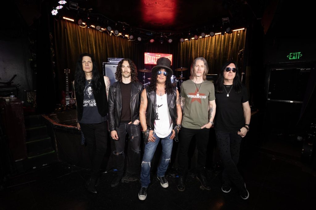 Slash wearing his signature top hat and sunglasses stands with Todd Kerns, Frank Sidoris, Myles Kennedy and Brent Fitz inside the Viper Room in Los Angeles.