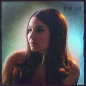 Alisan Porter with long dark hair against a softly illuminated blue and green background on the cover of her album PORTER.
